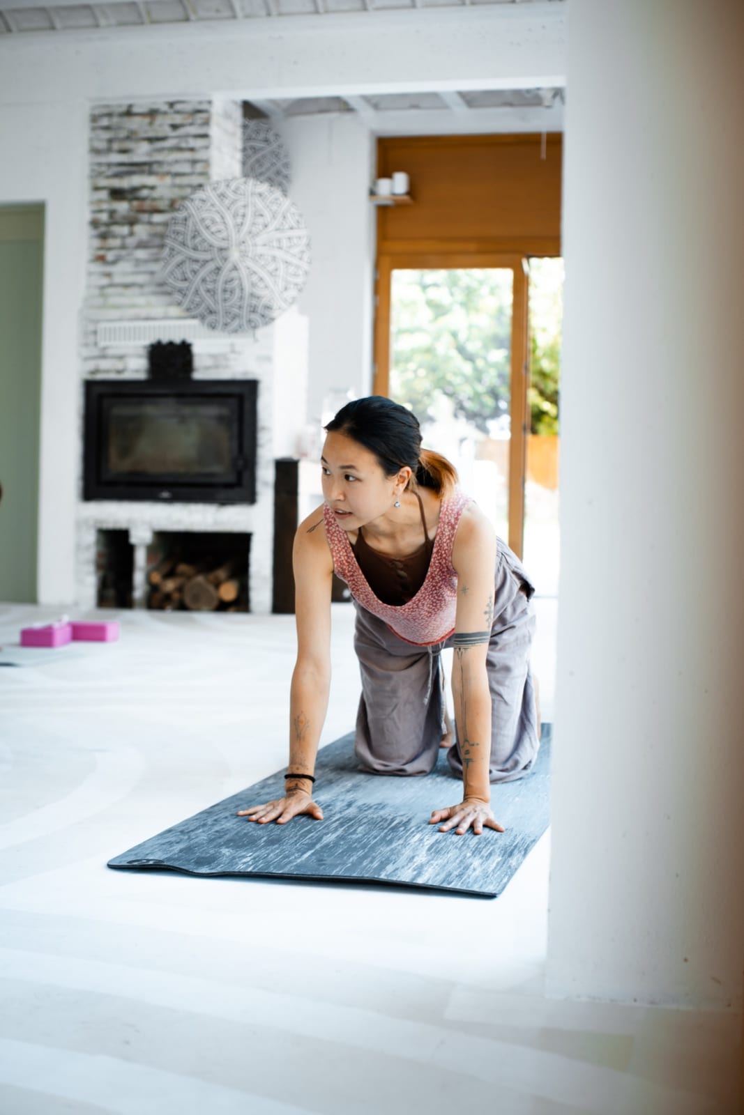 A practitioner on her mat, weight on her hands, gaze carried into the distance