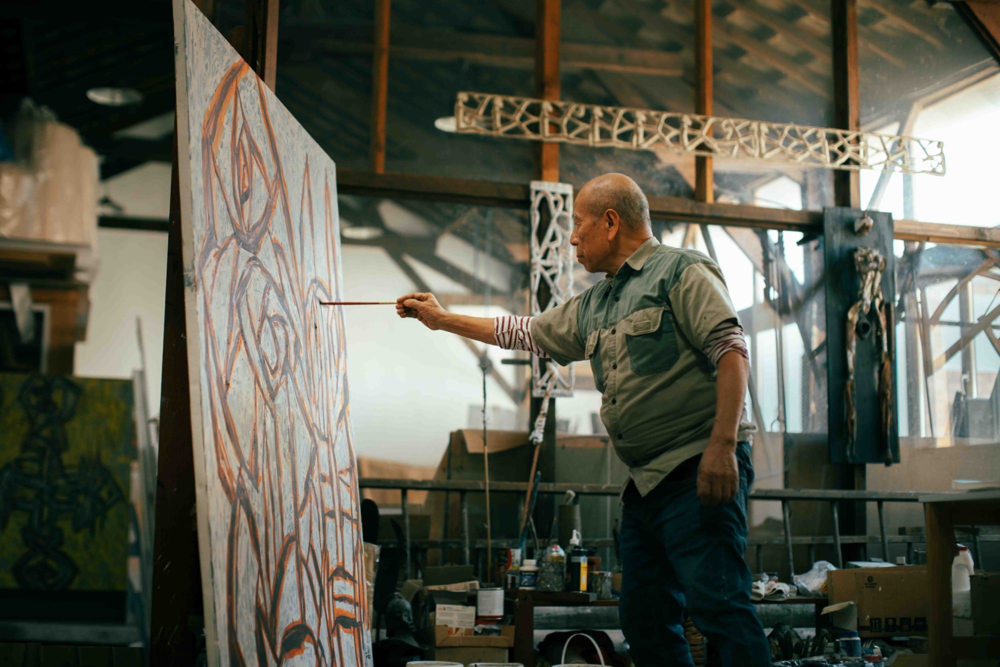 A-Sun Wu peignant une grande toile dans son atelier