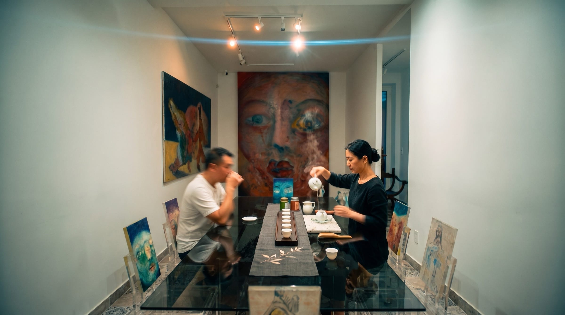 Mood image: tea served at the glass table of “A Table Face”, before Alixe Fu's canvases